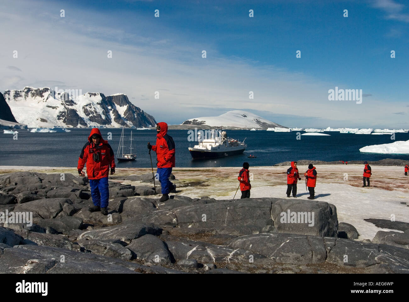 I turisti il check out di un pinguino papua Pygoscelis papua colonia su stand isola Charcot porta occidentale della penisola antartica Antartide Foto Stock
