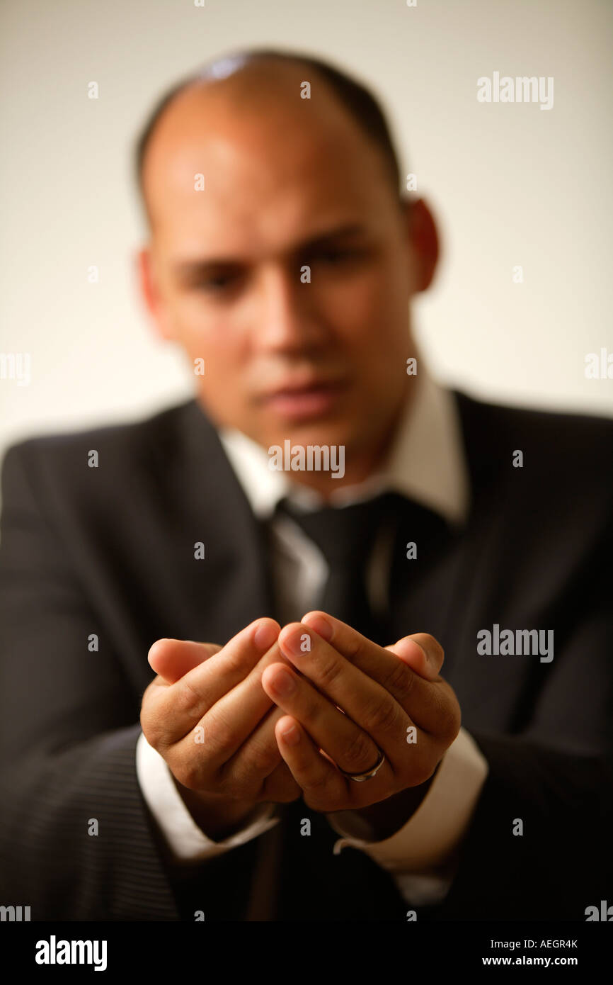 Giovane imprenditore tenendo le mani a tazza. Foto Stock