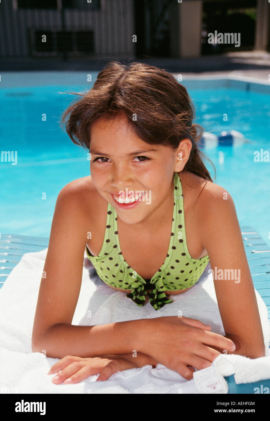 Etnie diverse 9-11 anno vecchia ragazza sulle sdraio vicino alla piscina ritratto signor © Myrleen Pearson Foto Stock