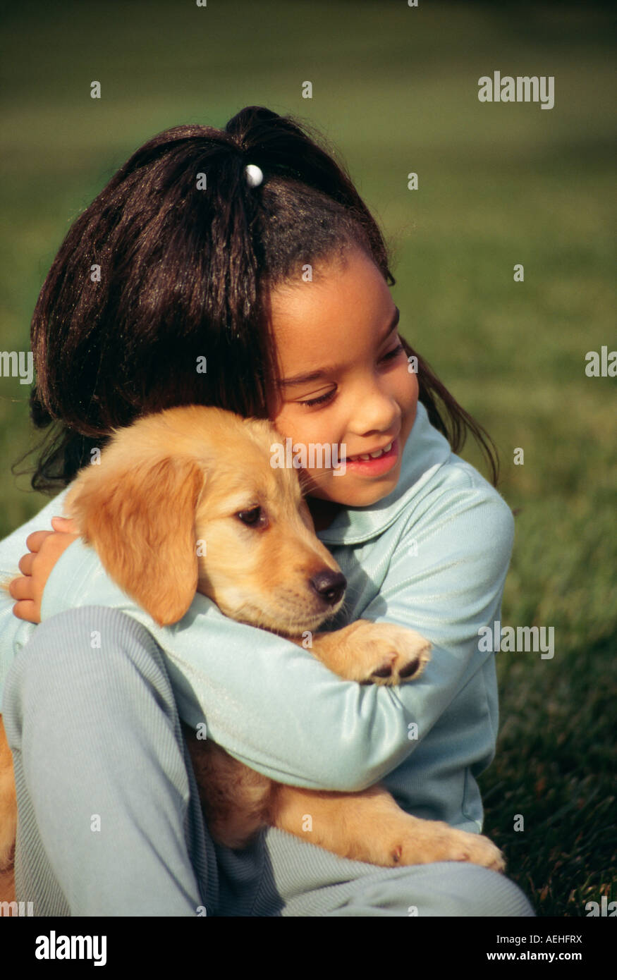 Da 5 a 7 anno di età tenendo la riproduzione di cucciolo di cane da vicino il golden retriever pup diversità etnico razziale diversi copia il profilo laterale al di sopra di alta signor © myrleen pearson Foto Stock