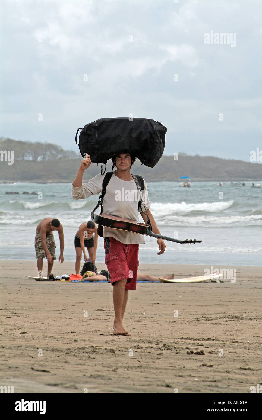Un musicista camminando sulla spiaggia Tamarindo, Costa Rica Foto Stock