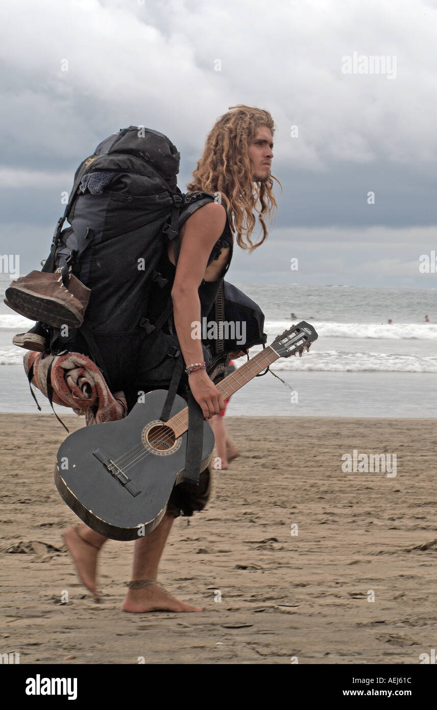 Un musicista camminando sulla spiaggia Tamarindo, Costa Rica Foto Stock