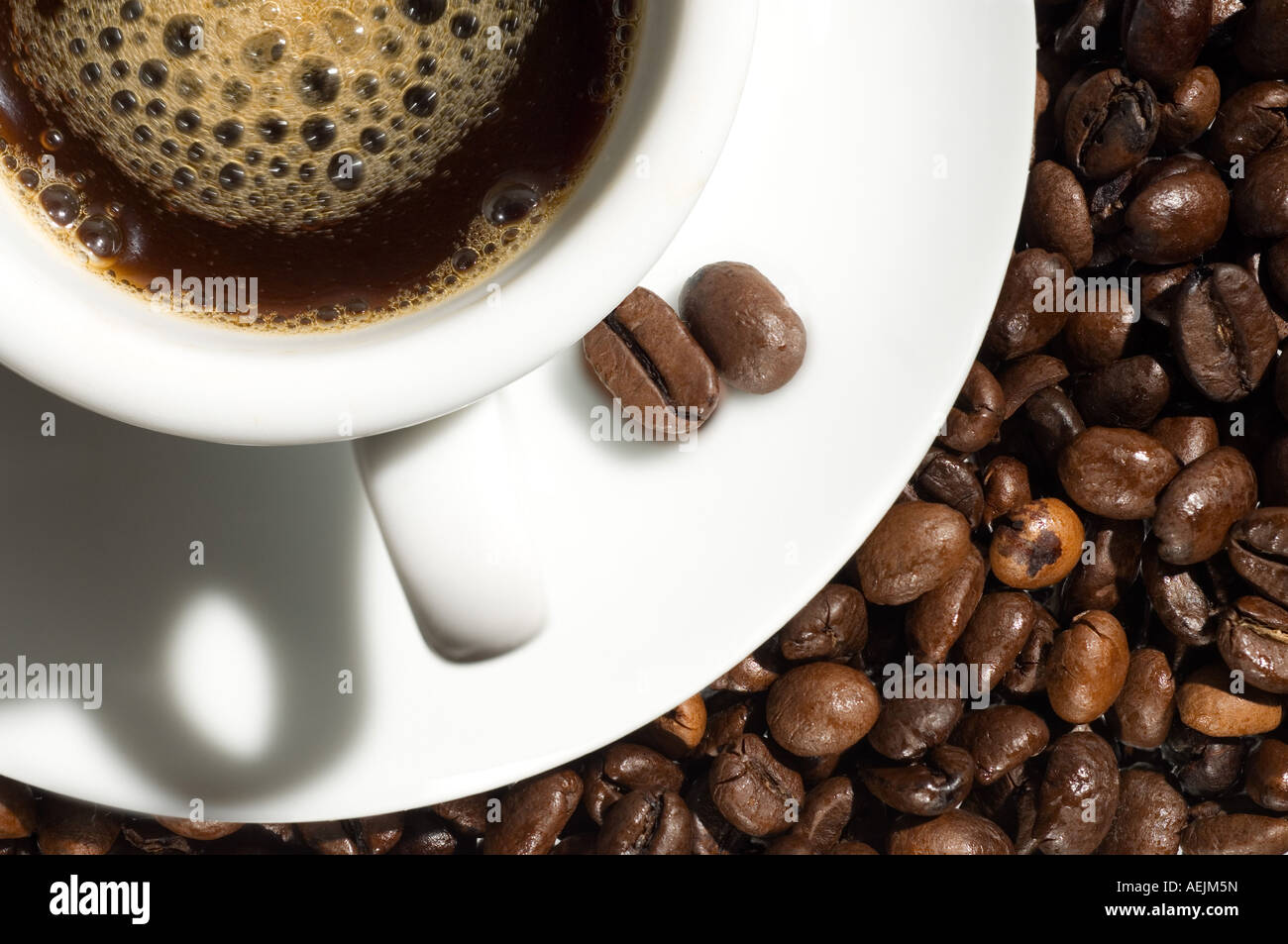 Una tazza di caffè nei pressi di chicchi di caffè tostati Foto Stock