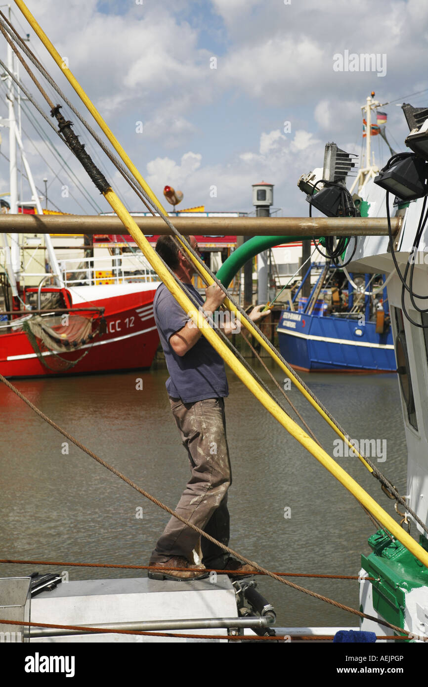 Fisherman dipinge il coltello da pesca verde, porto di dornumersiel, Frisia orientale, Bassa Sassonia, Germania Foto Stock