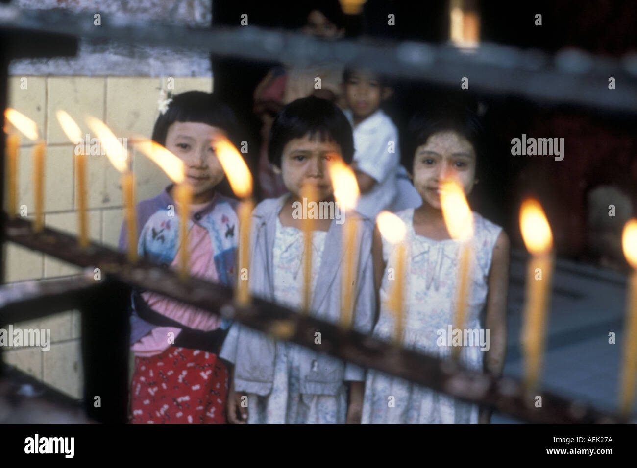 Tre bambine in un tempio buddista con candele, Birmania (ora Myanmar)1969 Foto Stock