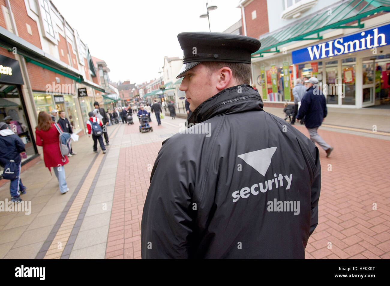 Una guardia di sicurezza orologi shopper in Lichfield centro città Foto Stock