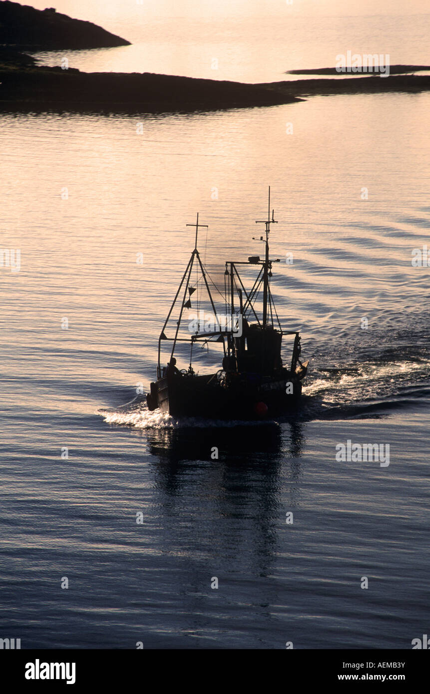 Una barca da pesca di tornare a casa e di Oban al tramonto. Foto Stock