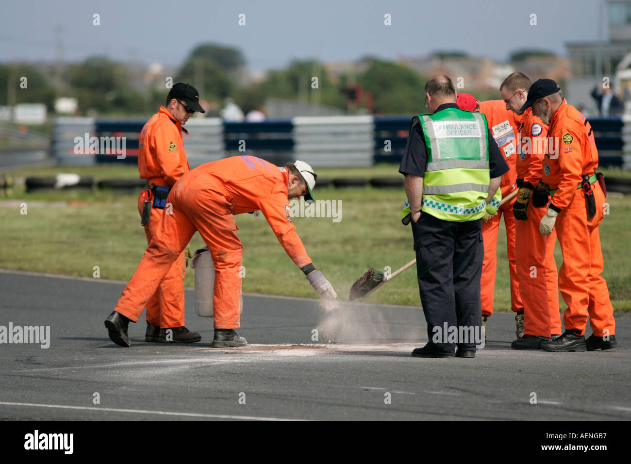 Il Marshalls fissare in polvere di cemento su fuoriuscite di olio in pista sul circuito di Kirkistown contea di Down Foto Stock