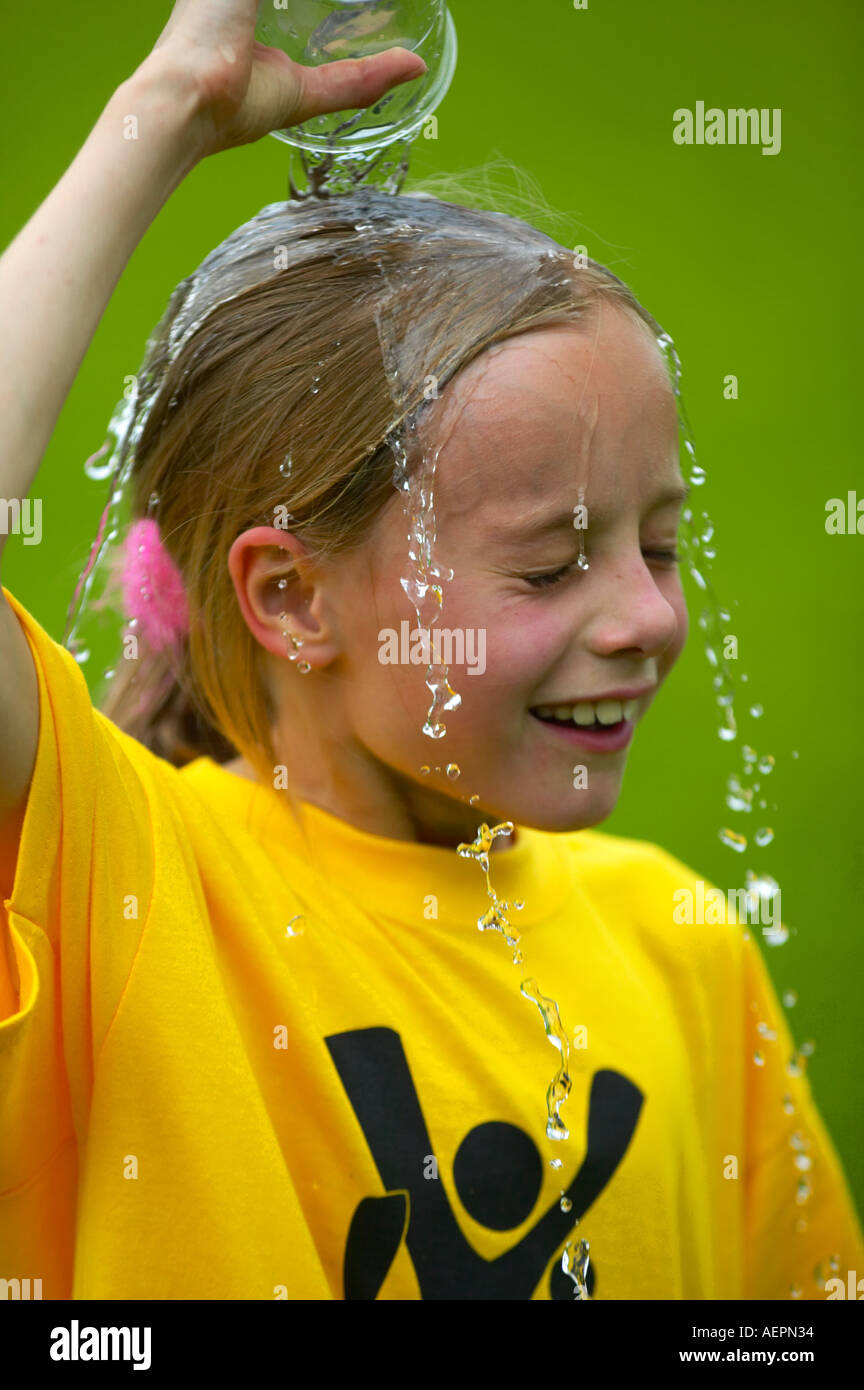 Giovane ragazza il raffreddamento con acqua dopo una gara Foto Stock