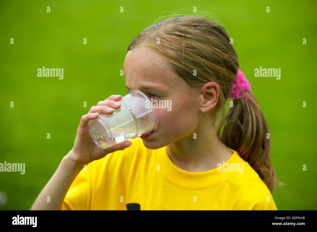 Giovane ragazza il raffreddamento con acqua dopo una gara Foto Stock