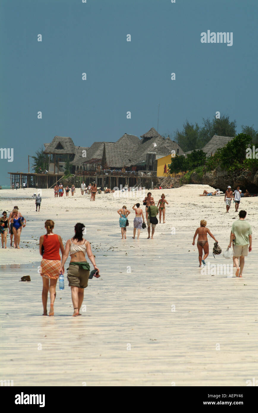 I turisti a piedi lungo la spiaggia di Nungwi a Zanzibar. Tanzania, Africa. Foto Stock