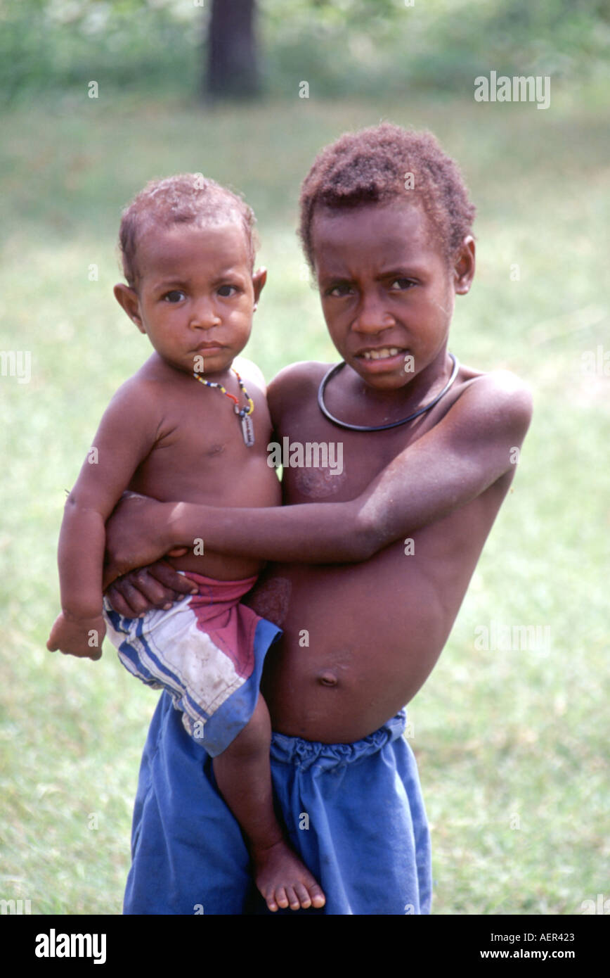 Ragazzo che trasportano il fratello nel fiume Sepik regione di Papua Nuova Guinea Foto Stock