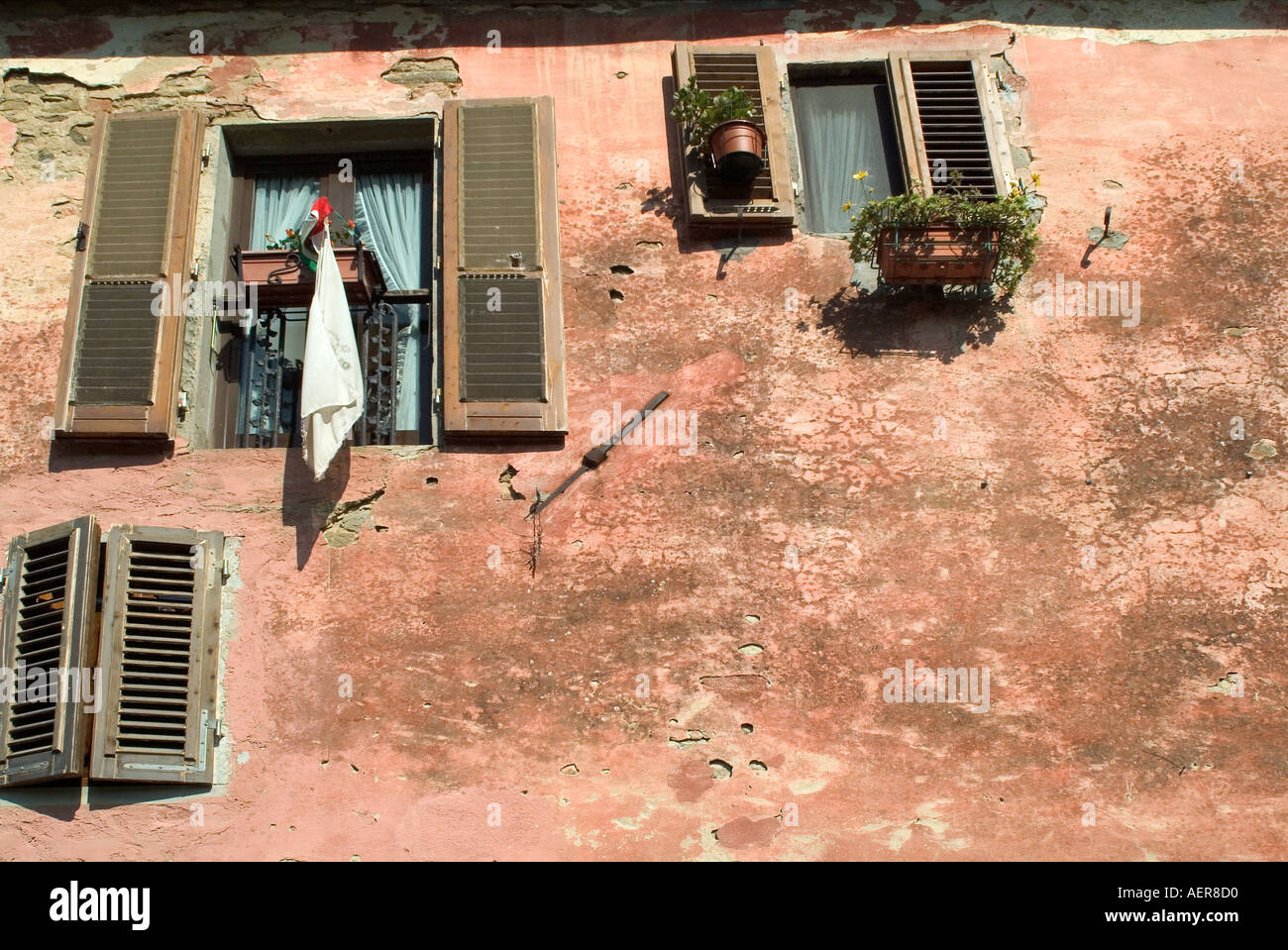 Toscana Italia vecchie finestre con persiane e dissolvenza peeling vernice su edificio dell'antica città medievale di il Borro in Toscana Ital Foto Stock