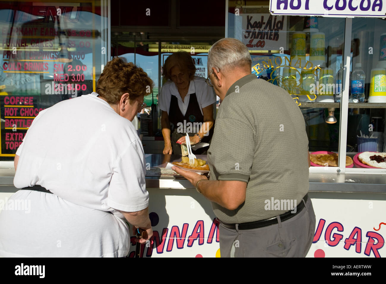 ILLINOIS Grayslake vecchio uomo e donna acquisto torta di imbuto con topping dal fast food booth Lake County Fair forche Foto Stock