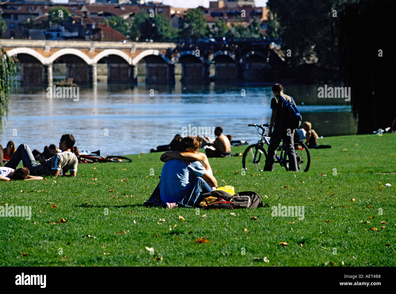 Coppia giovane abbracciando sulle rive del fiume Garonna Toulouse Francia Foto Stock