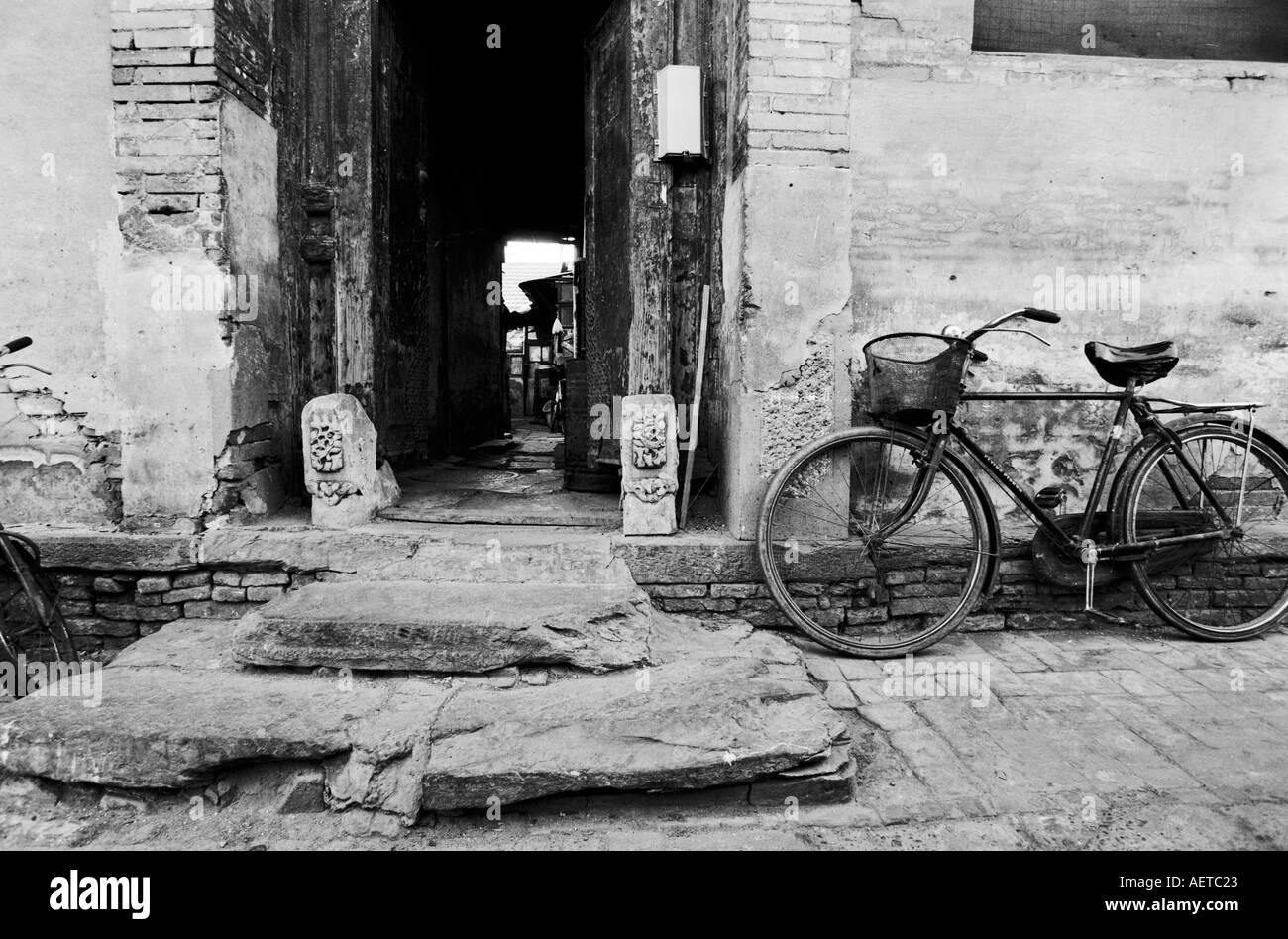 Una bicicletta parcheggiata fuori una vecchia casa in Ju er hutong di Pechino poco prima fu demolita nel 2003 Cina Foto Stock