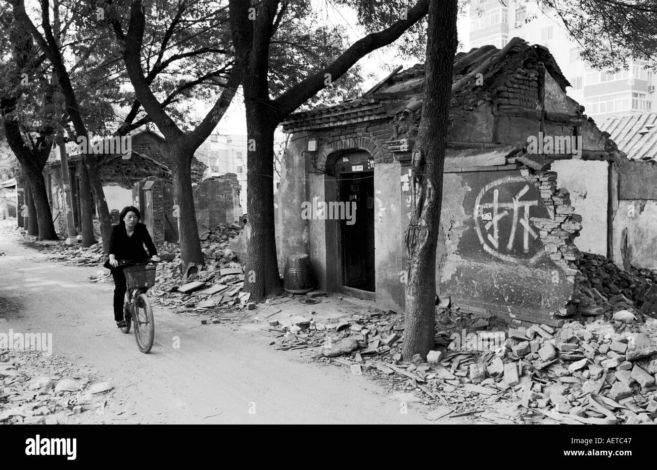 Una signora in bicicletta in una demolita hutong di Pechino 2003 Cina Foto Stock