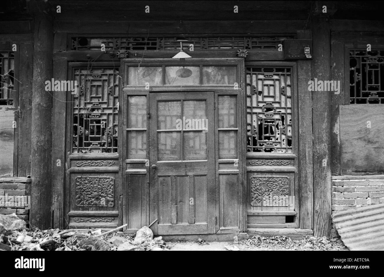 Un vecchio originale in legno ornati porta in una casa cortile sotto la demolizione in un hutong di Pechino 2002 Cina Foto Stock
