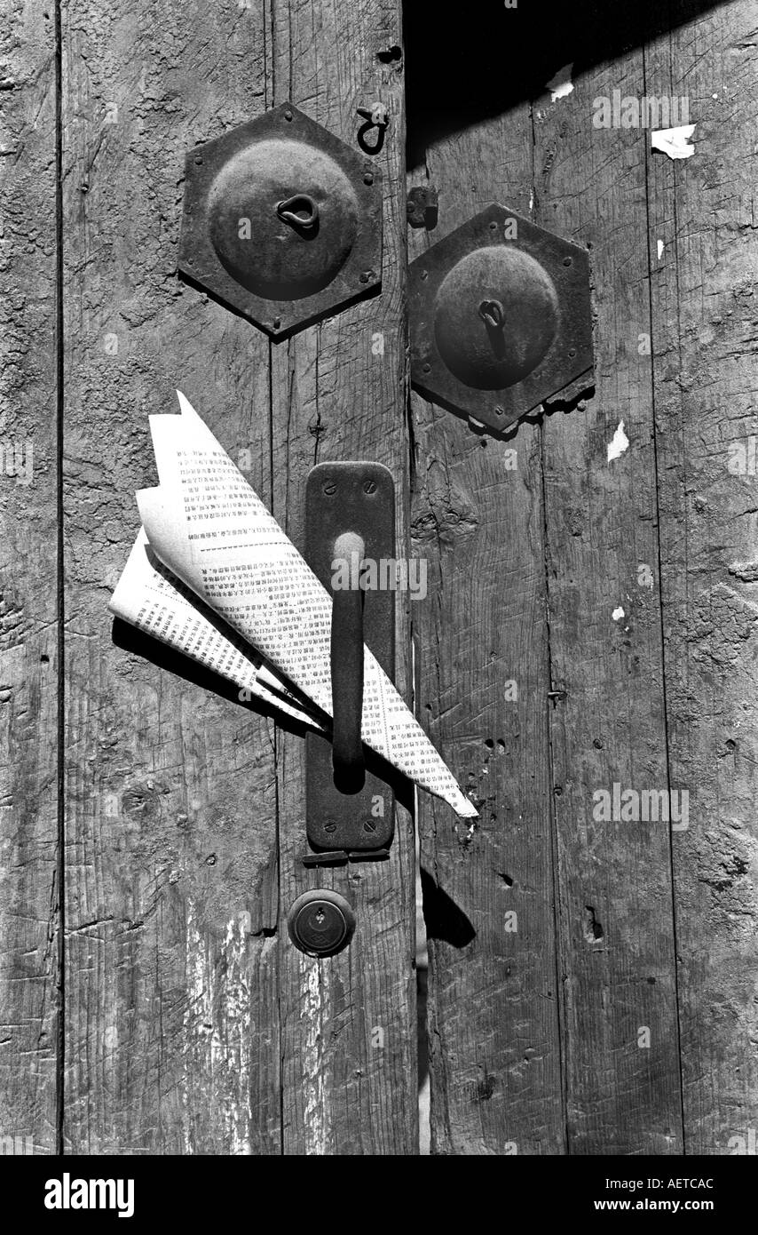 Un giornale è ripiegato ed incollato nel manico di una vecchia porta in un hutong di Pechino 2003 CINA Foto Stock