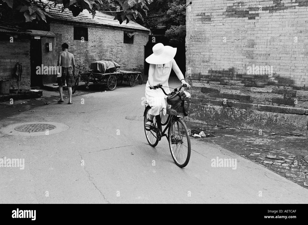 Una signora in sella ad una bicicletta in un hutong di Pechino durante l'estate 2003 la Cina Foto Stock