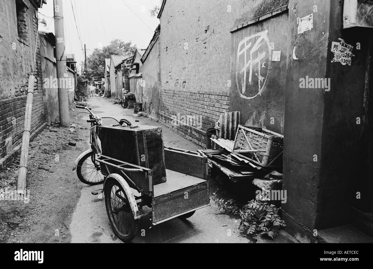 Una bicicletta carrello carico di bagagli come una famiglia si sposta al di fuori della loro hutong home poco prima che esso venga demolita 2003 Foto Stock