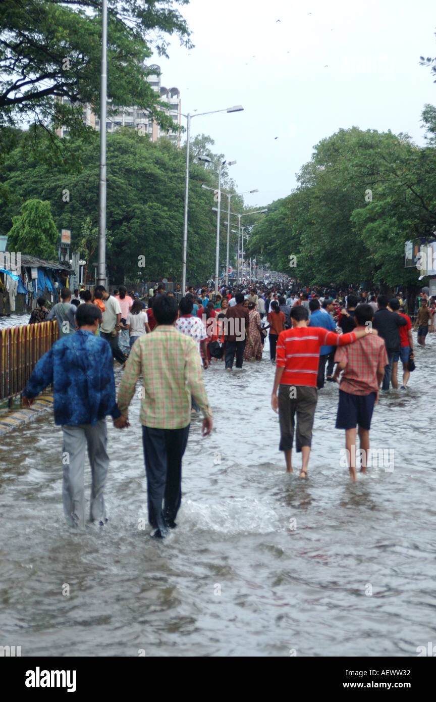 Persone che camminano nella strada allagata piogge monsoniche a Bombay ora Mumbai India Foto Stock