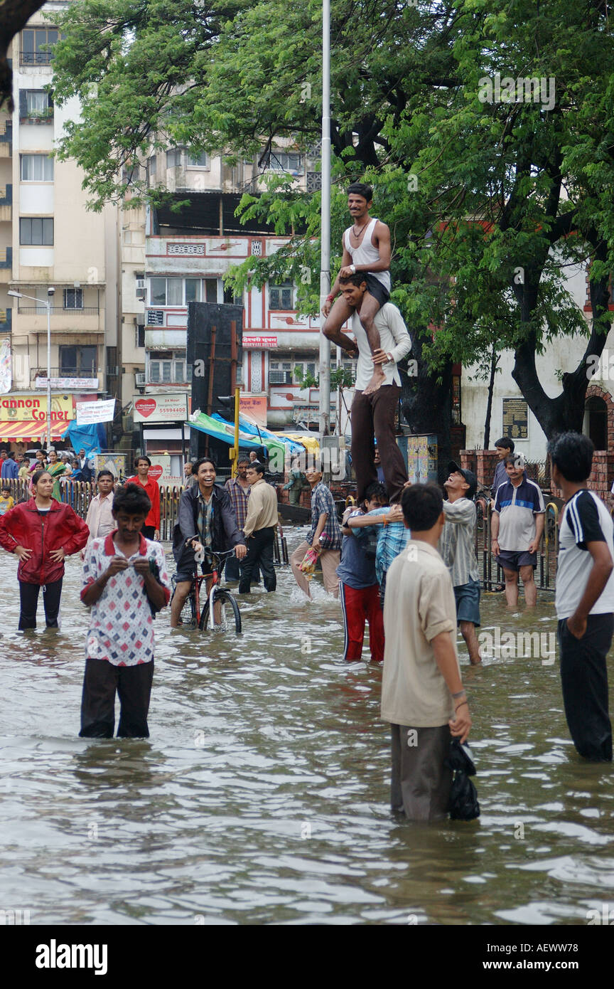 Persone a giocare in strada allagata dopo piogge monsoniche a Bombay ora Mumbai India Foto Stock