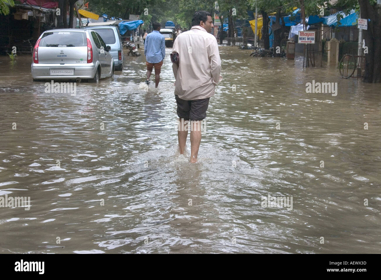 Uomo che cammina in strada allagata dopo la pioggia monsonico, Bombay, Mumbai, Maharashtra, India, Asia Foto Stock