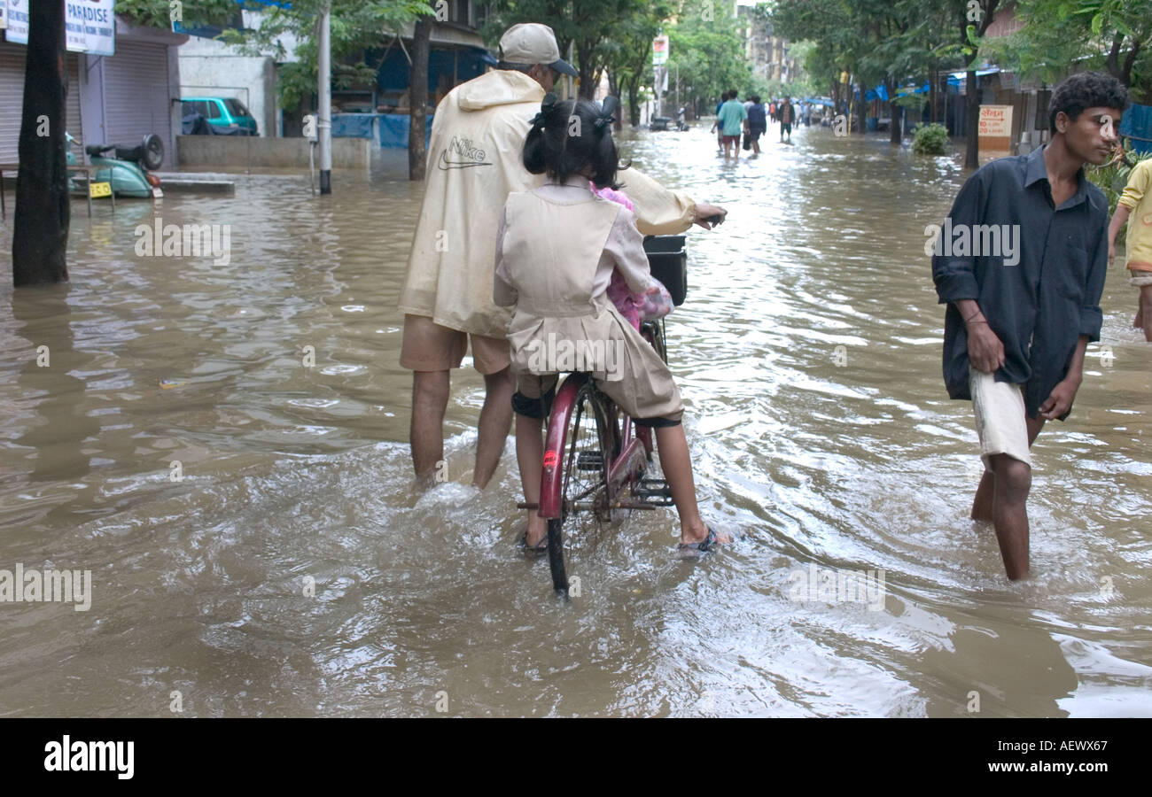 Bambino in bicicletta in strada allagata con monsonore pioggia a Bombay ora Mumbai Maharashtra India Asia Foto Stock