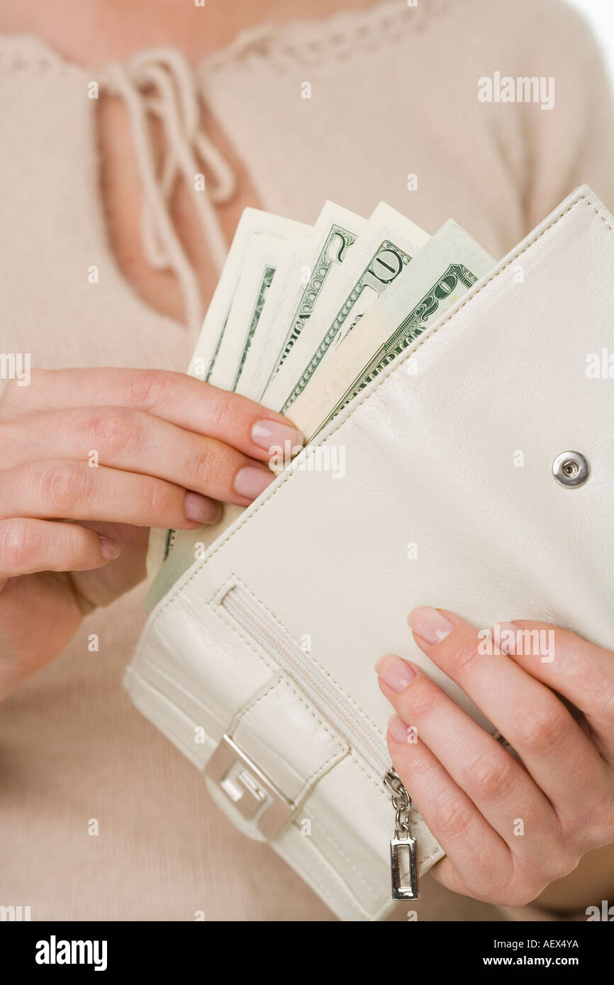 Donna mettendo in contanti wallet Foto Stock
