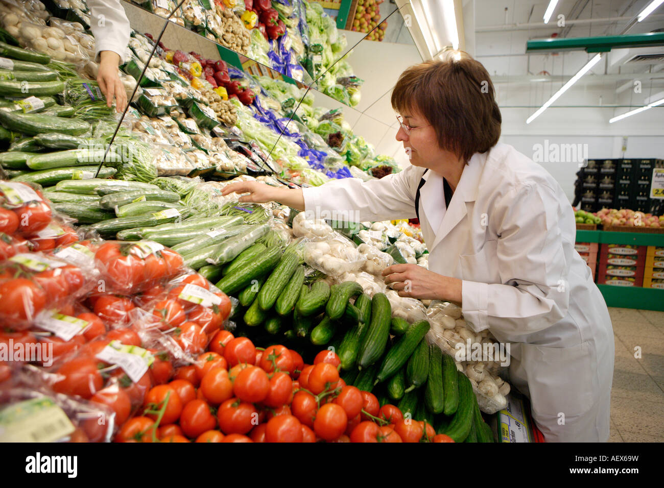 Controllo della qualità alimentare Inspector verifica la qualità della frutta e della verdura reparto in un supermercato Foto Stock