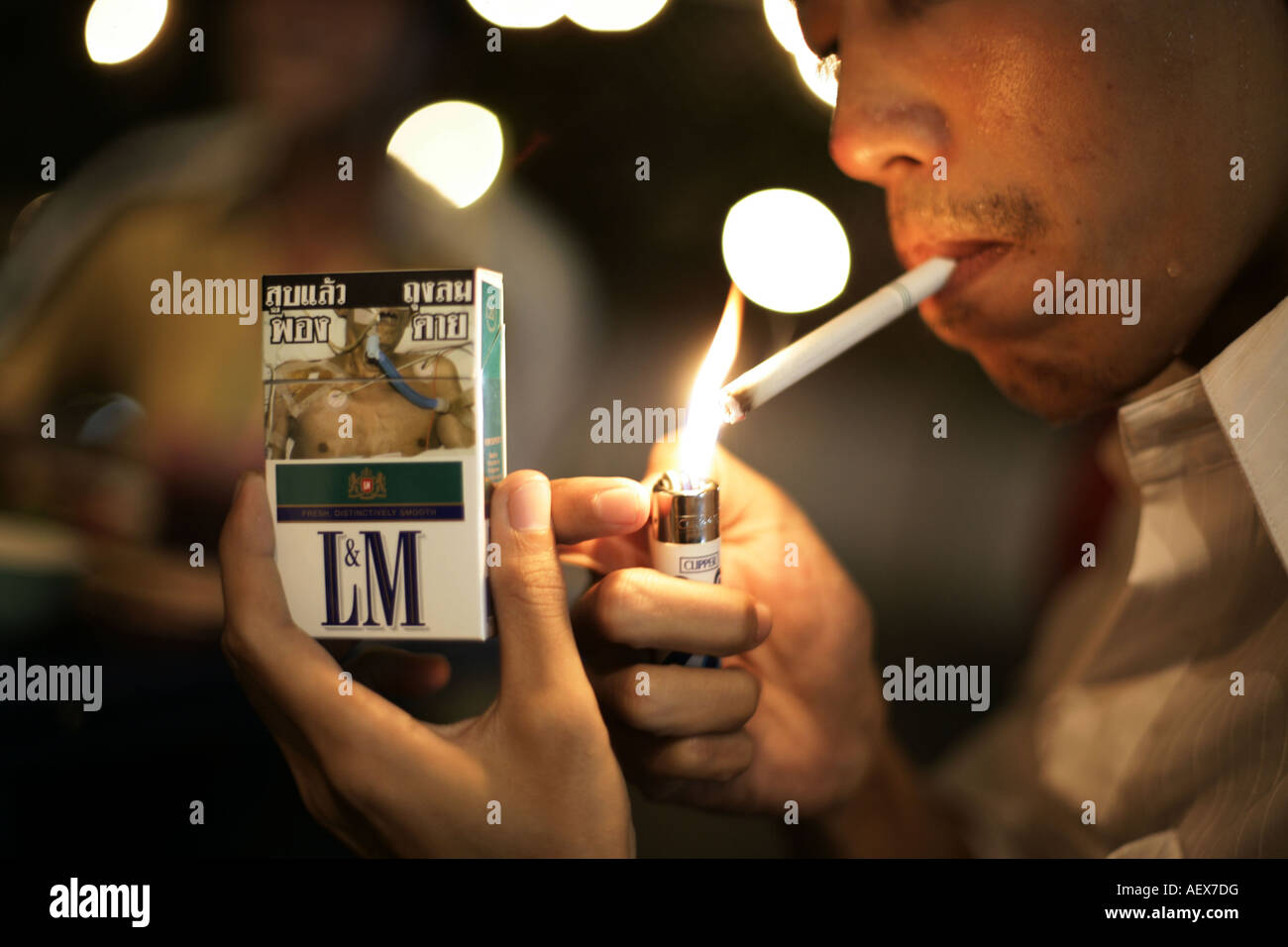 La legge non fumatori: fumatore è un fulmine una sigaretta a Bangkok in Tailandia Foto Stock