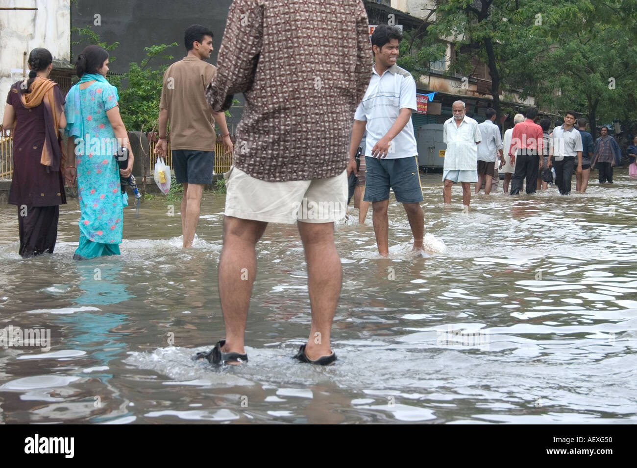 Famiglia a piedi in strada allagata dopo la pioggia monsonico, Bombay, Mumbai, Maharashtra, India, Asia Foto Stock