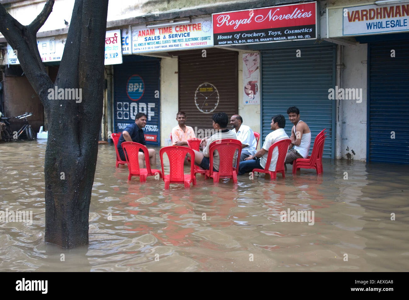La gente seduta nella strada allagata a causa di piogge monsoniche a Bombay ora Mumbai India Foto Stock