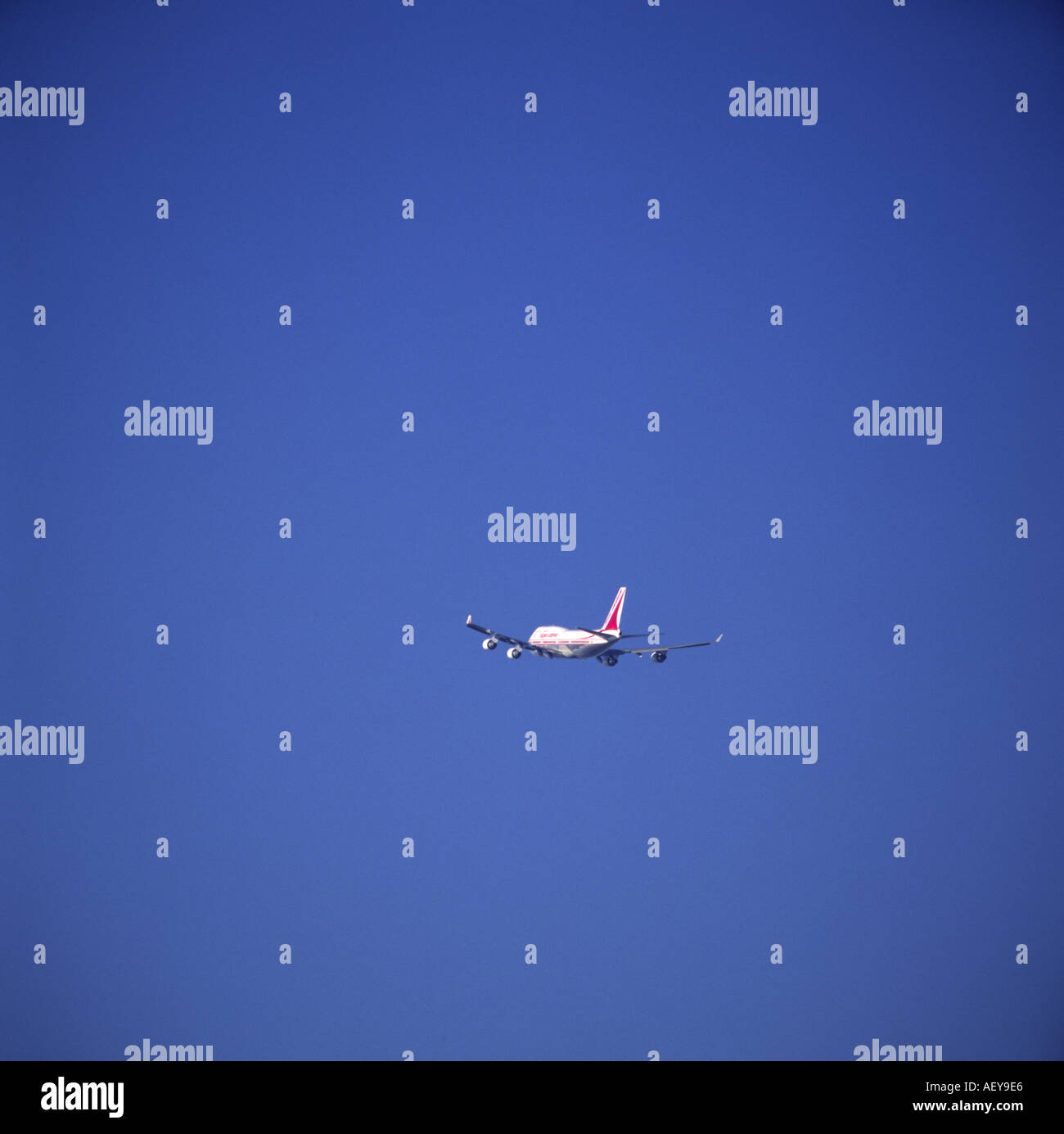 747 Jumbo volare lontano nel cielo blu Foto Stock