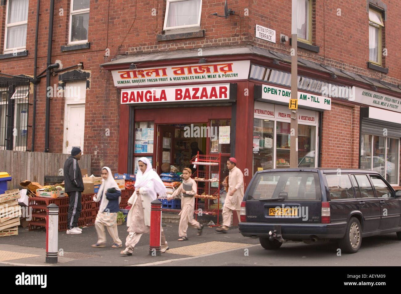 Musulmani asiatici oltrepassando un angolo asiatici shop in Beeston Leeds Foto Stock