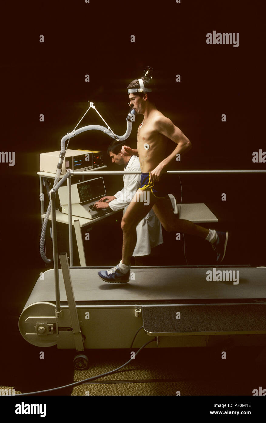 Uomo che corre sul tapis roulant durante medica test di stress Foto Stock