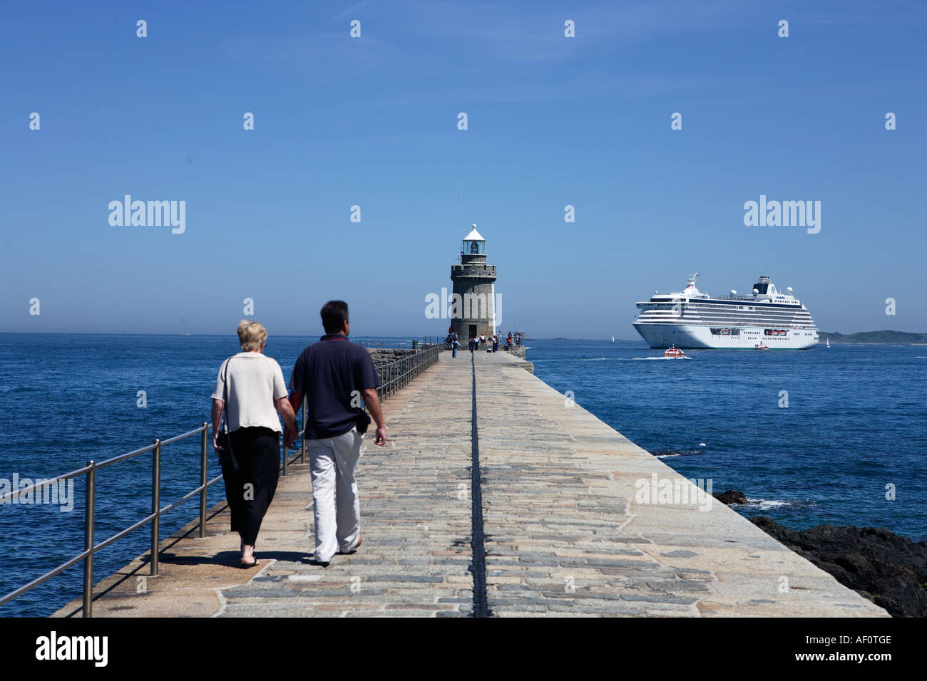 Giovane camminando lungo il Cobb in Saint Peter Port Harbour a Guernsey Isole del Canale della Manica UK Foto Stock