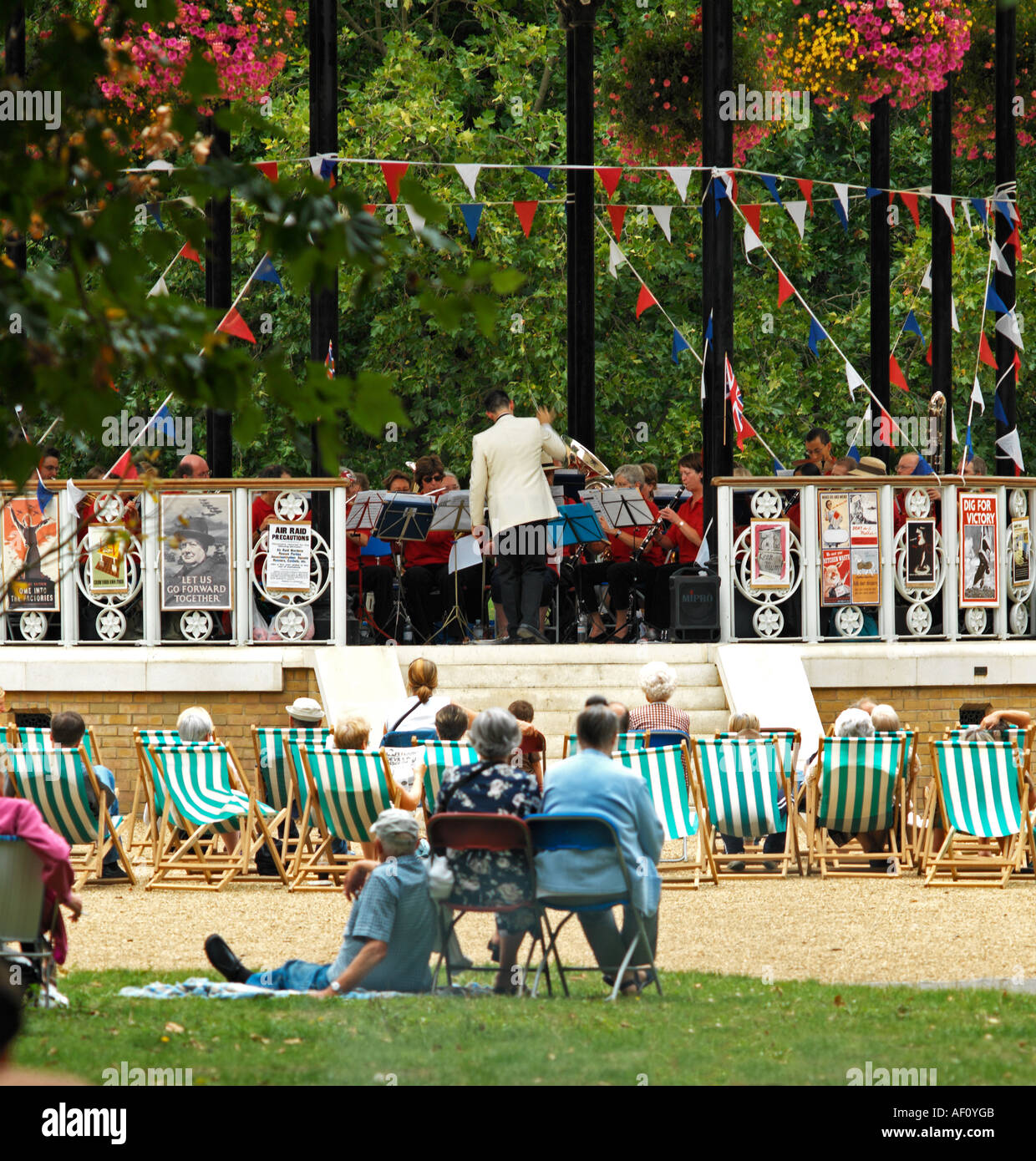 Sedie a sdraio Park Bandstand nessun modello di rilascio richiesto: Viste posteriore distanza così raccolto tutti irriconoscibile Foto Stock