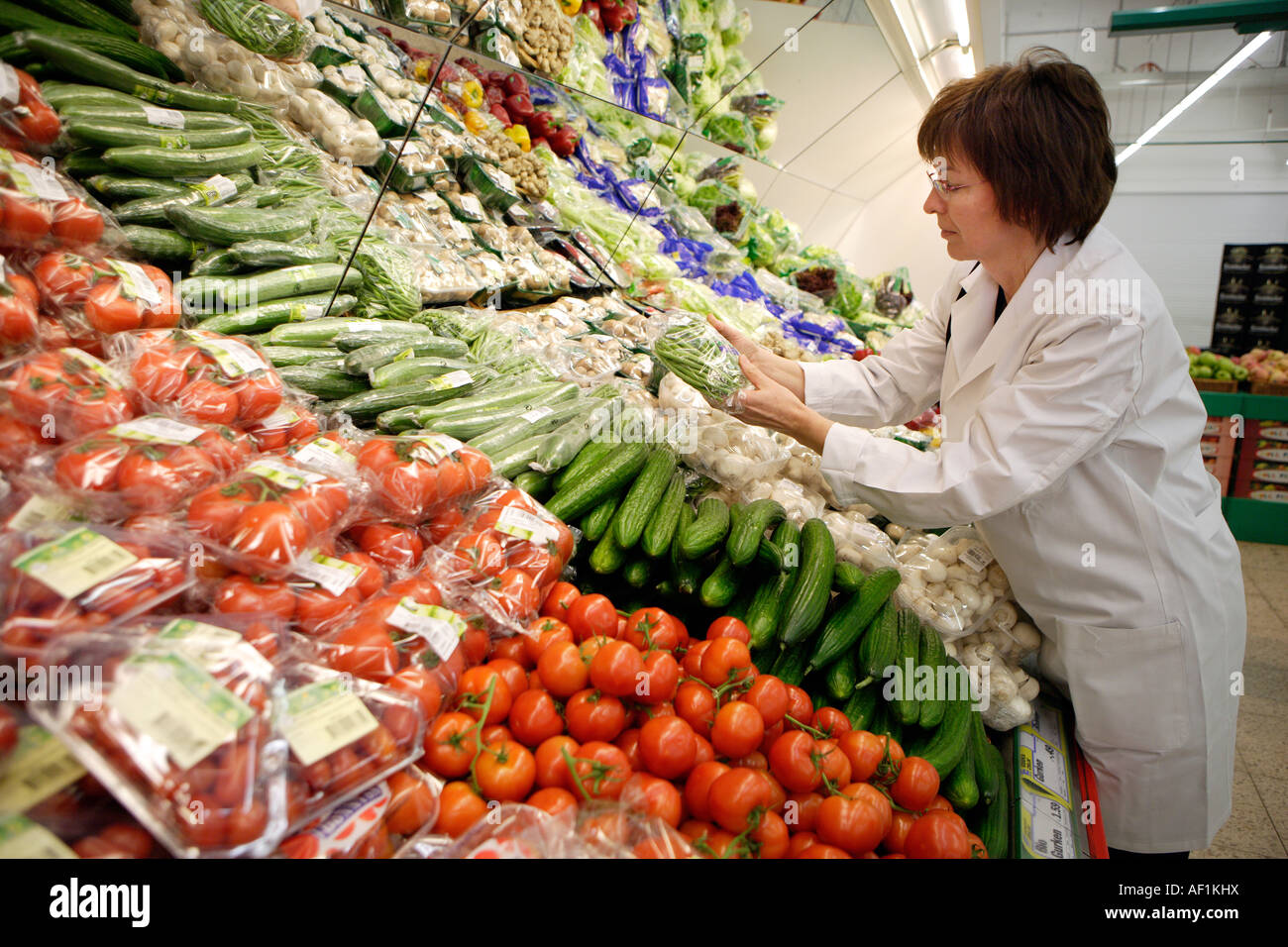 Controllo della qualità alimentare Inspector verifica la qualità della frutta e della verdura reparto in un supermercato Foto Stock