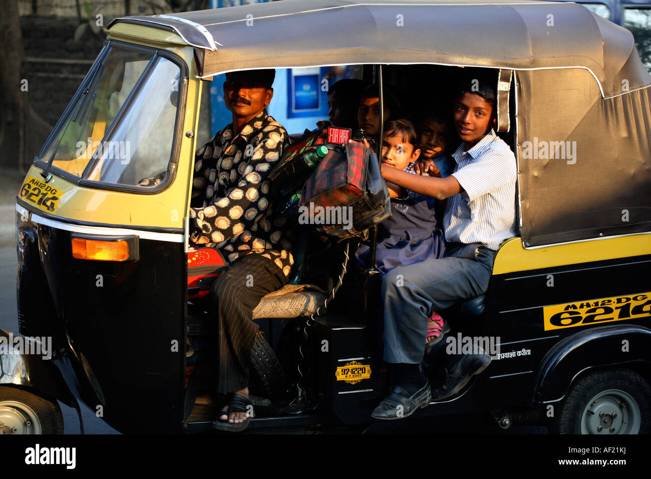 I bambini della scuola indiana si sono impazziti nel risciò automatico sulla loro strada a casa dalla scuola, Pune, India Foto Stock