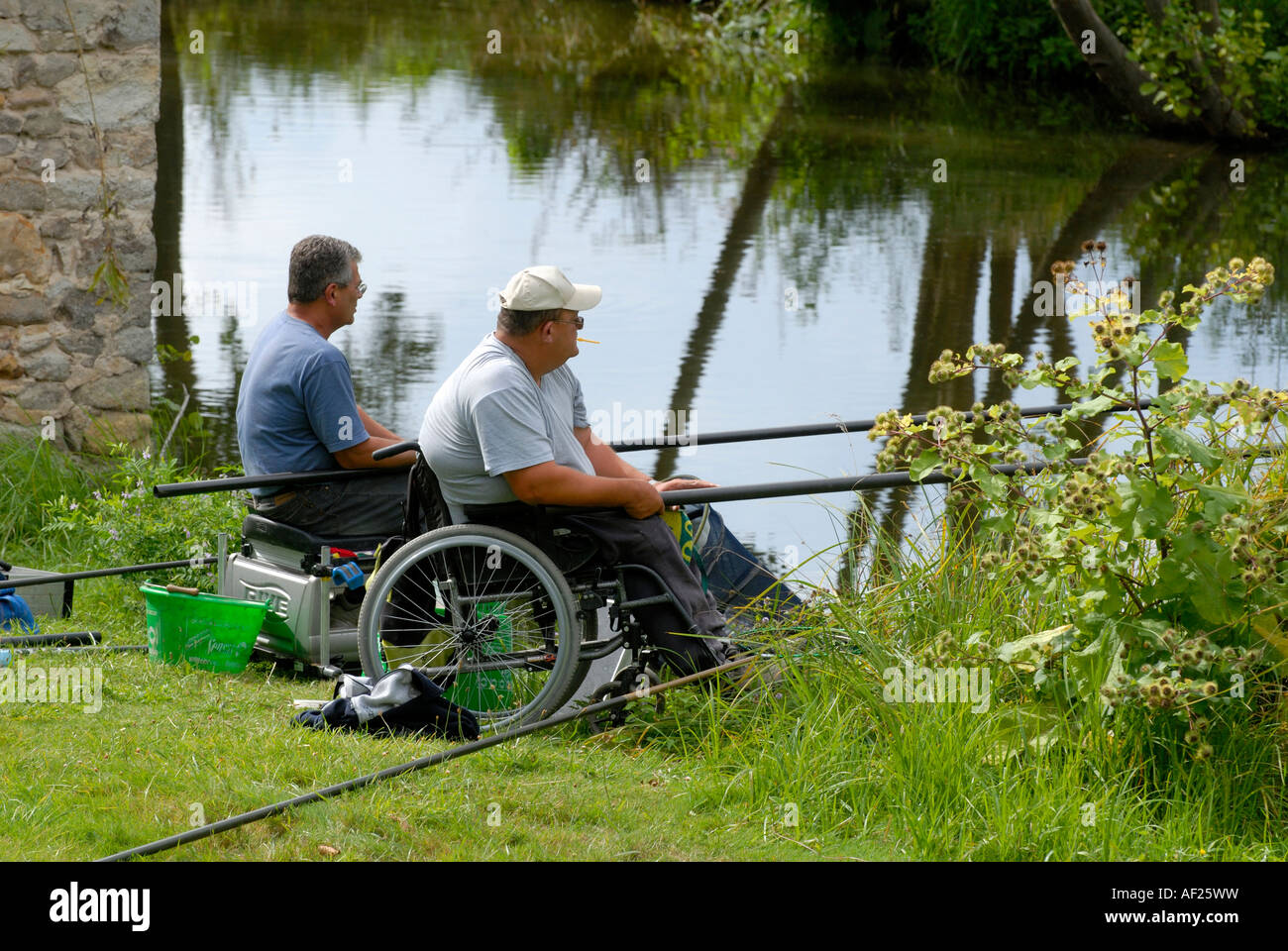 Disabilitato uomo helper e la pesca nel fiume Claise, Indre, Francia. Foto Stock
