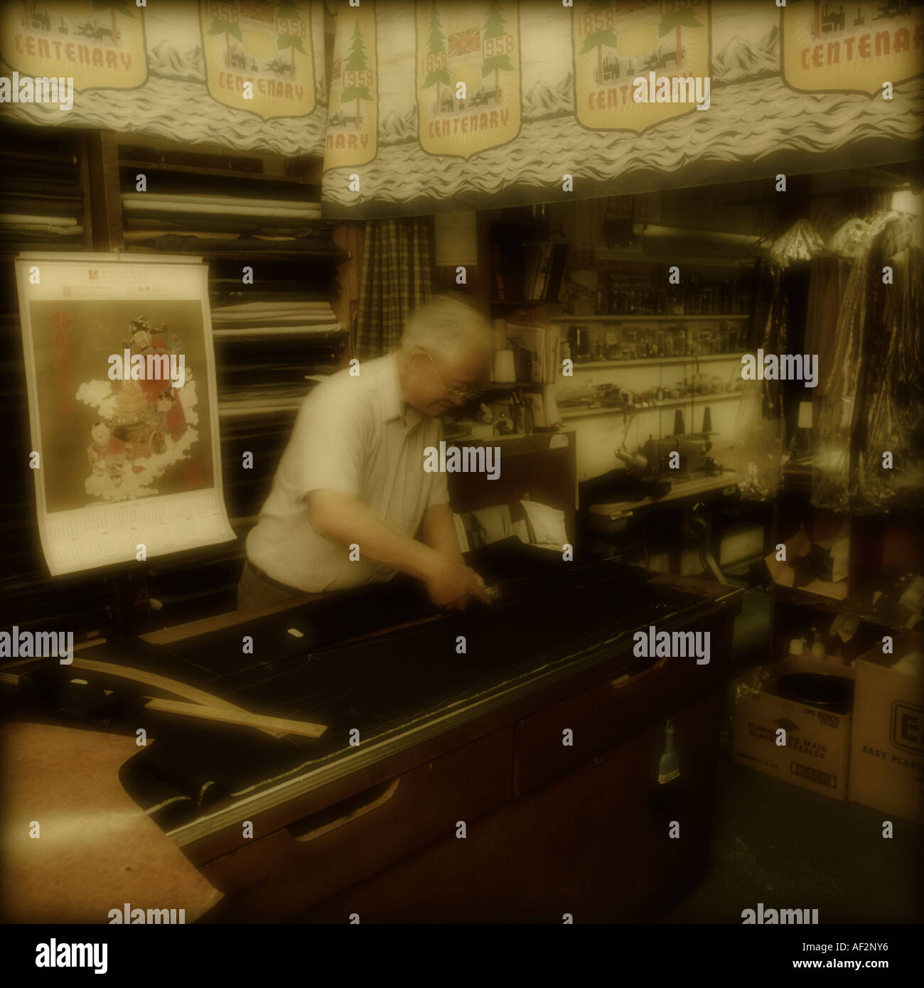 Sarto cinese canadese che lavora nel suo negozio per realizzare abiti personalizzati. Foto Stock