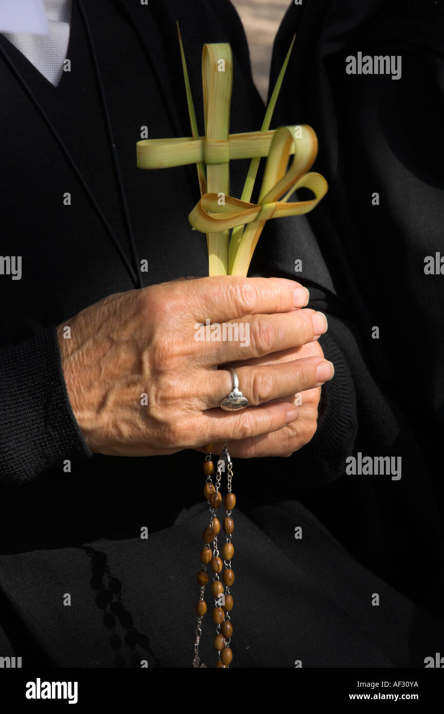 Israele Gerusalemme Sainte Anne Chiesa la Domenica delle Palme processione cattolica close up di una monaca s mano azienda 2 croci fatte di palm leav Foto Stock