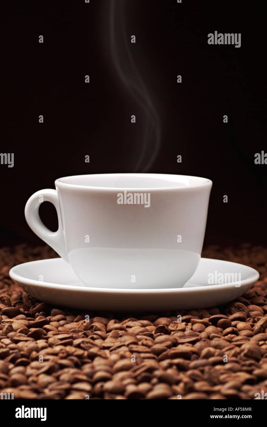 Tazza di caffè in chicchi di caffè con vapore ascendente Foto Stock