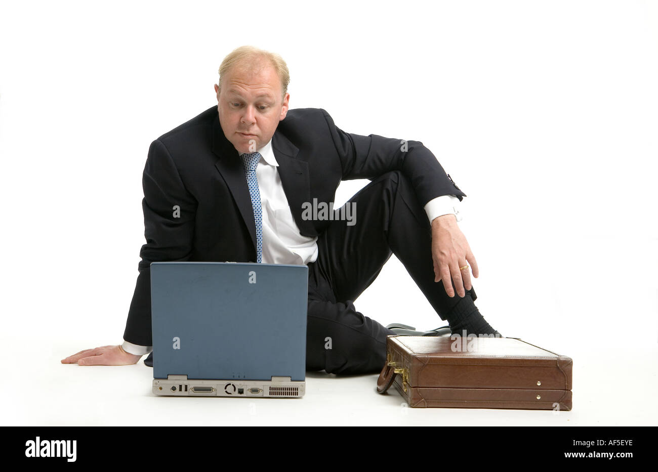 Executive seduta sul pavimento utilizzando computer lap top Foto Stock