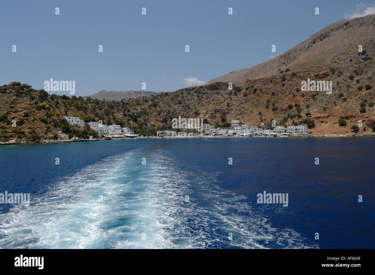 Loutro città dal traghetto guardando indietro sulla scia di barche a sud ovest di Creta Foto Stock