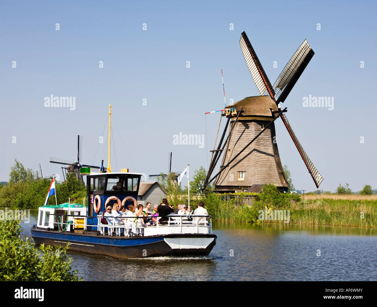 I turisti a Kinderdijk, Paesi Bassi, Europa - Visualizzazione di un mulino a vento Foto Stock