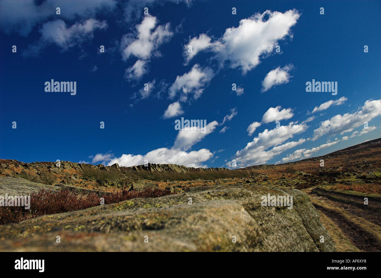 Vista delle rocce Burbage contro un luminoso blu cielo a molla Foto Stock