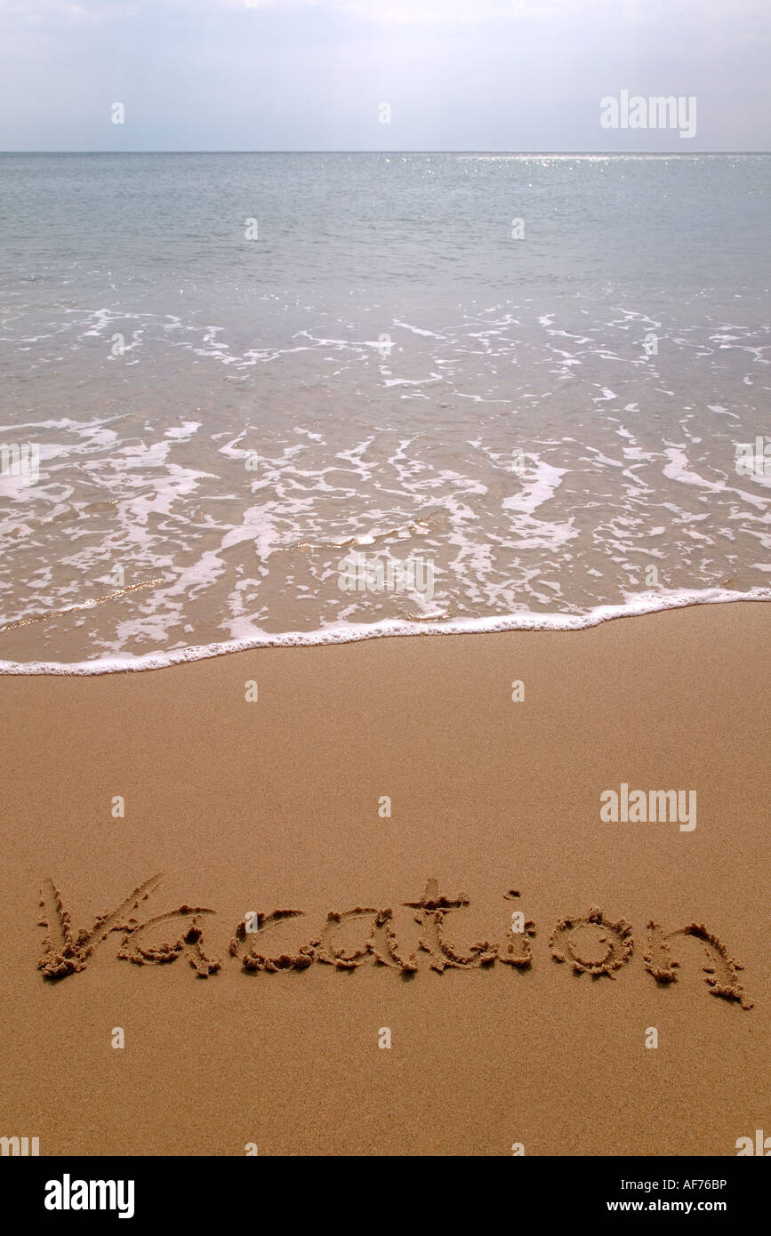 Vacanza scritto in sabbia sulla spiaggia Foto Stock